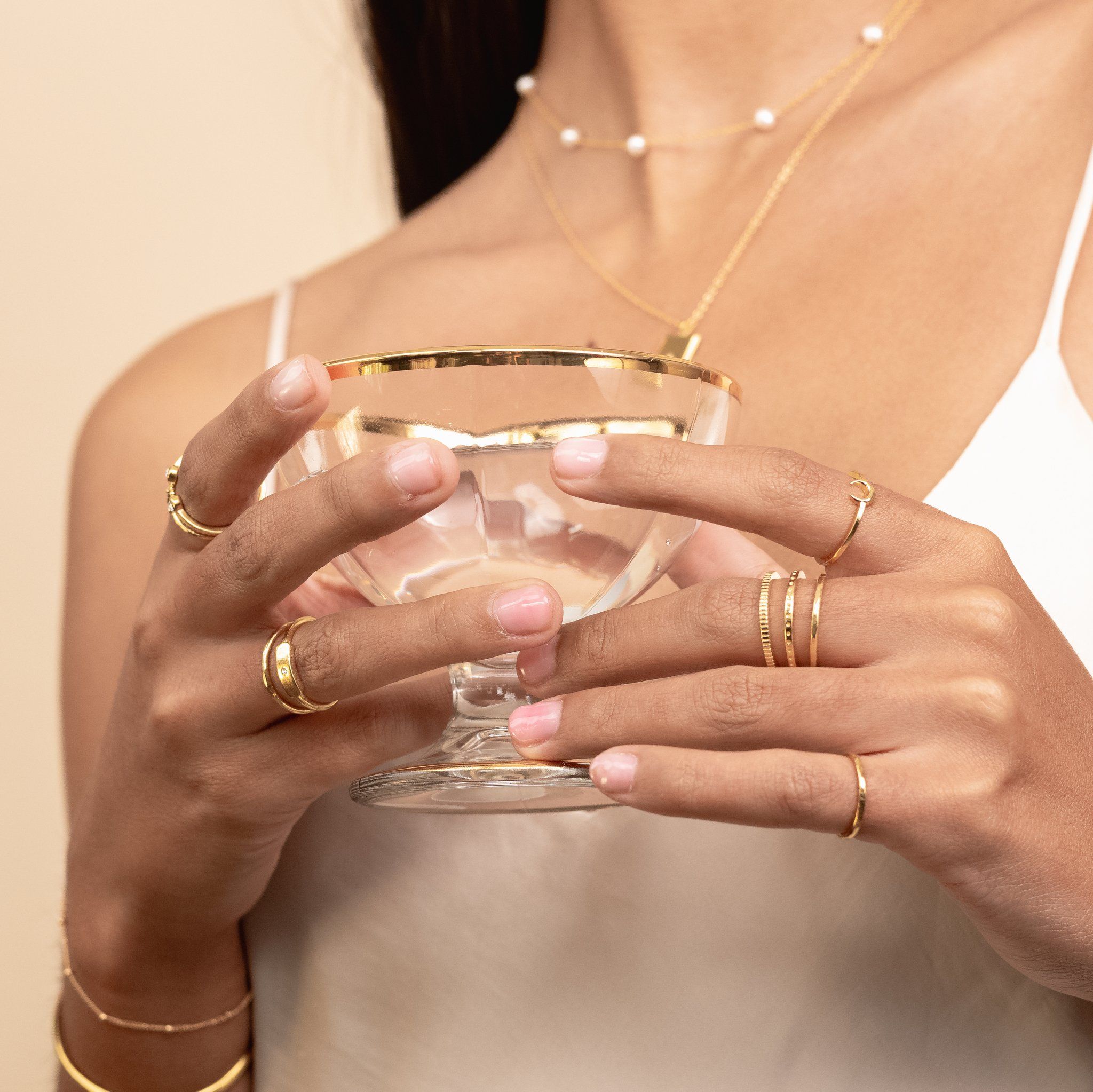 Model wearing dainty gold Coin ring, dotted ring, hammered band ring, moon ring, Champagne Glass, Katie Dean Jewelry