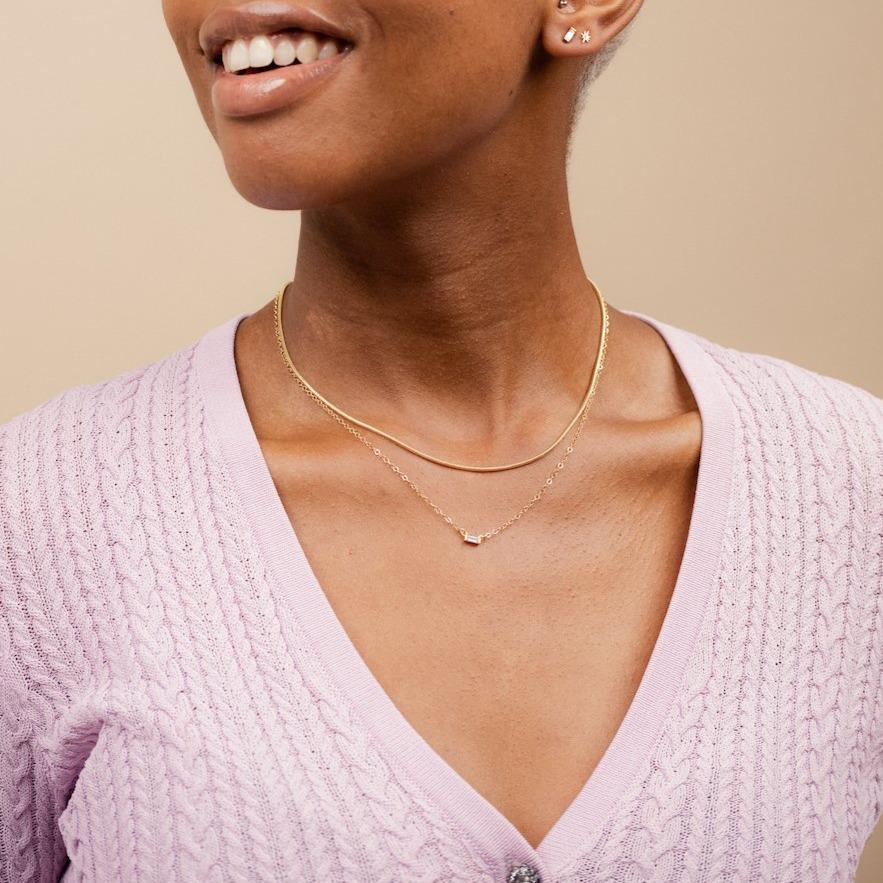 The dainty gold Elegant Necklace Set by Katie Dean Jewelry as seen on a model wearing a lavender cardigan.
