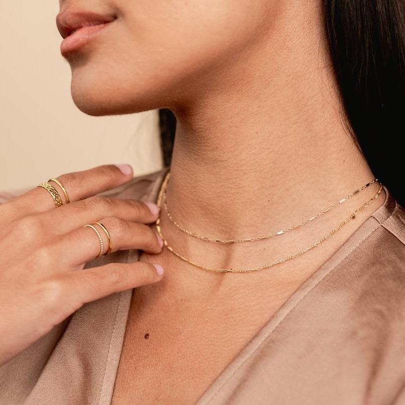 Model wearing brown silk top, looking to the side, wearing the Everyday Necklace Set is your new go-to jewelry look. Handmade in California by Katie Dean Jewelry. Included in this set: the Figaro Choker Necklace and Linked Choker Necklace