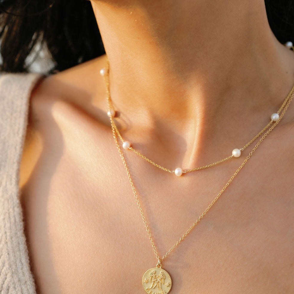 Pearl Necklace as seen on a model, layered with the Gemini Zodiac Necklace made in America by Katie Dean Jewelry