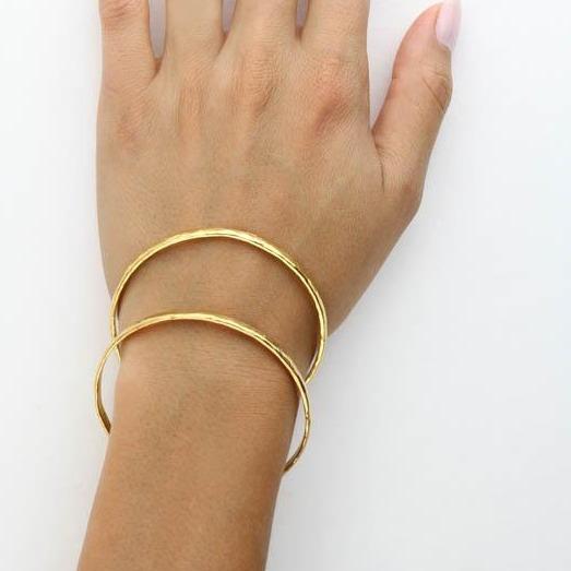 Image of models hand wearing the gold Hammered Bangle. 