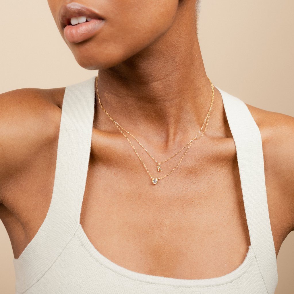Model wearing the dainty gold Initial Necklace and Birthstone Necklace, handmade in America by Katie Dean Jewelry