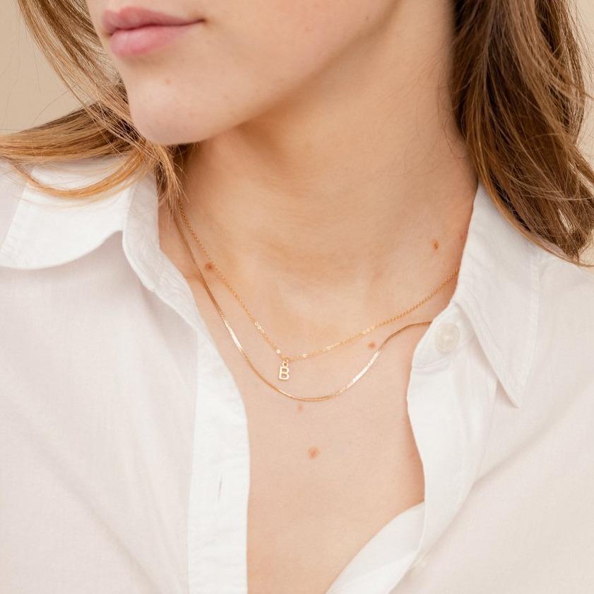 Model wearing the dainty gold Initial Necklace and Herringbone Chain Necklace, handmade in America by Katie Dean Jewelry