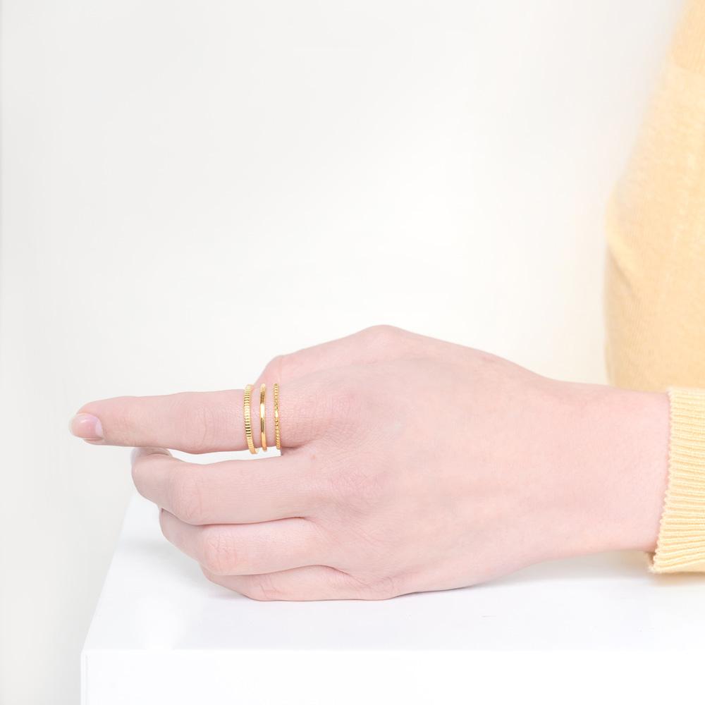 Image of models hand wearing the gold Minimal Stack against a white background.