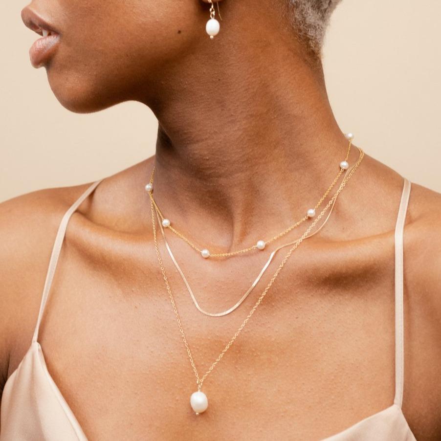 Model wearing the Pearl Choker Necklace, Herringbone Chain Necklace and Long Pearl Pendant Necklace, handmade in America by Katie Dean Jewelry