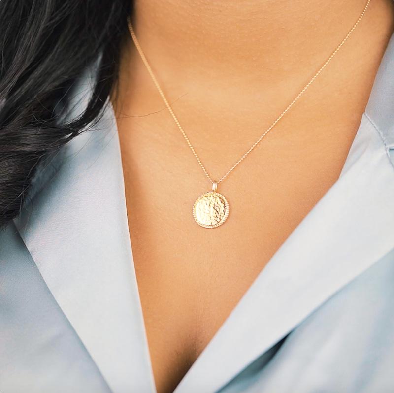 The Beaded Coin Necklace. The beaded edging and hammered finish on this coin charm makes it glisten beautifully in the light. It also layers perfectly with the Beaded Arch Necklace. Handmade in California by Katie Dean Jewelry. 